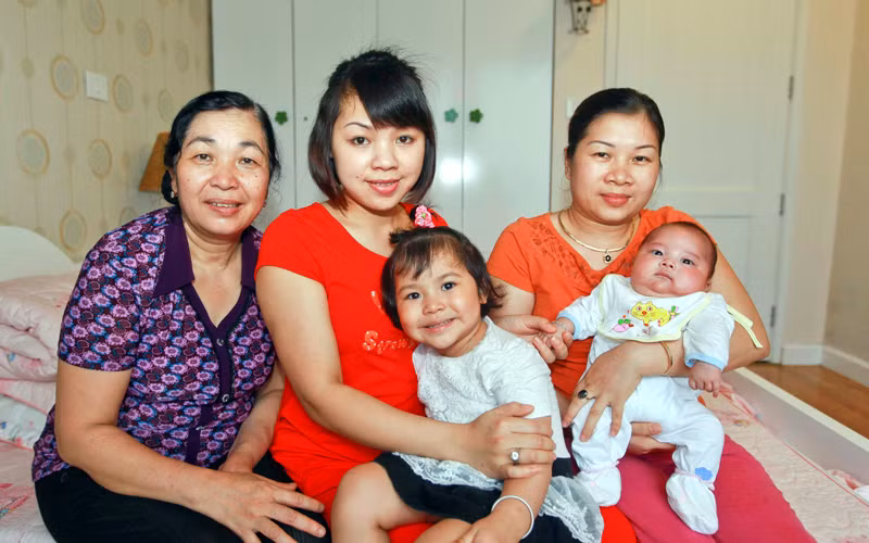 Cháu Cao Trung Dũng ngoài cùng bên phải trong vòng tay người thân