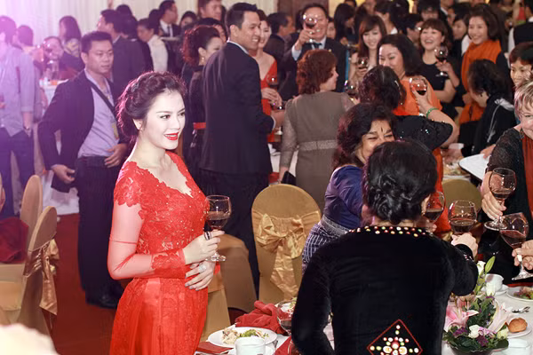 Trong buổi tiệc, cô vui vẻ đi chào hỏi mọi quan khách.