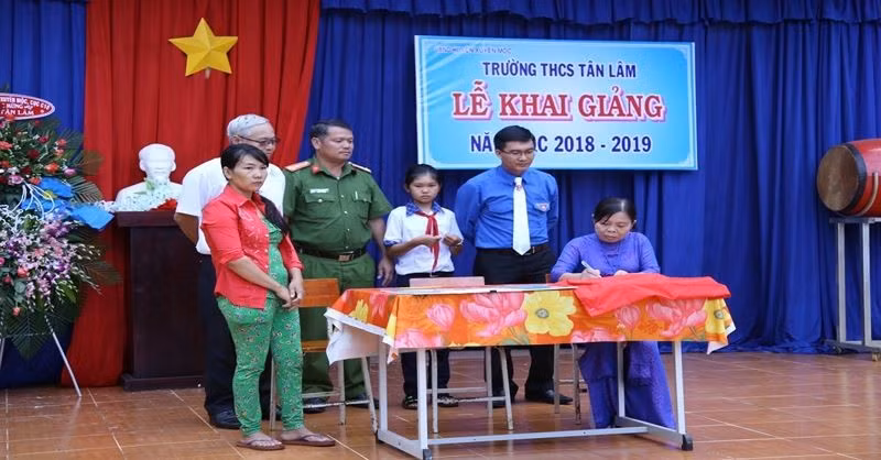 Cô Đặng Thị Nga, người ngồi, ký kết tài trợ học bổng toàn phần cho học sinh với nhà tài trợ