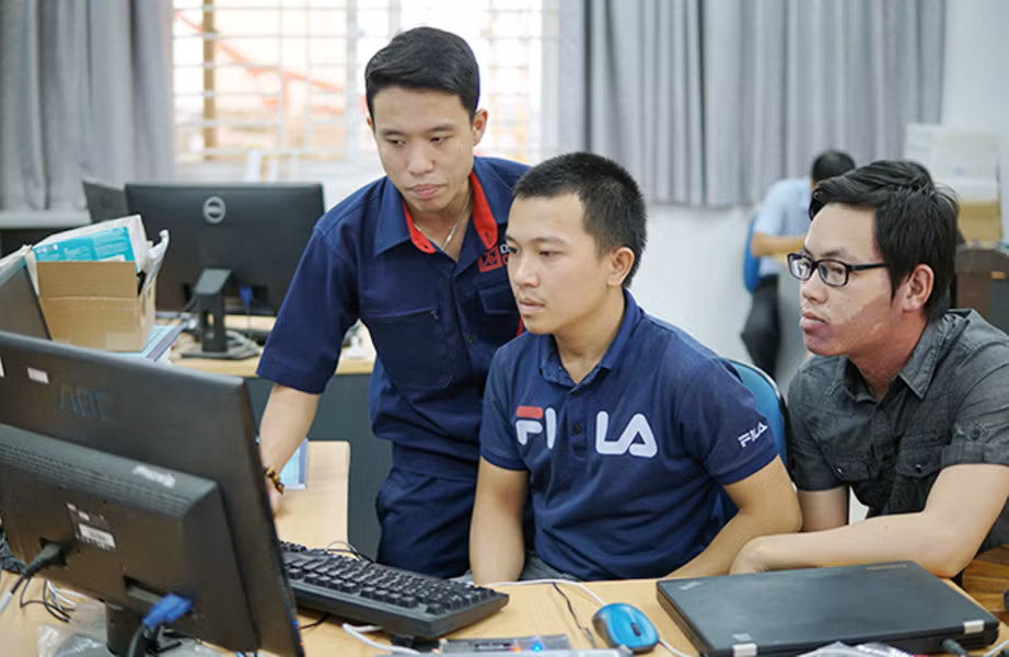 Nhóm sinh viên Nguyễn Thế Đức và Hồ Văn Chương đang được kỹ sư Tạ Quốc Việt (người đứng) hướng dẫn hoàn thiện sản phẩm. Ảnh: AN Nhóm sinh viên Nguyễn Thế Đức và Hồ Văn Chương đang được kỹ sư Tạ Quốc Việt (người đứng) hướng dẫn hoàn thiện sản phẩm. Ảnh: AN