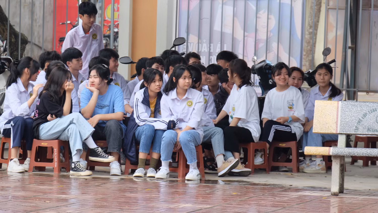 Khắc phục khó khăn, thời tiết, các em vẫn không bỏ vị trí mà tìm cho mình những chỗ trong sân trường, vừa trú mưa vừa nghe chia sẻ.