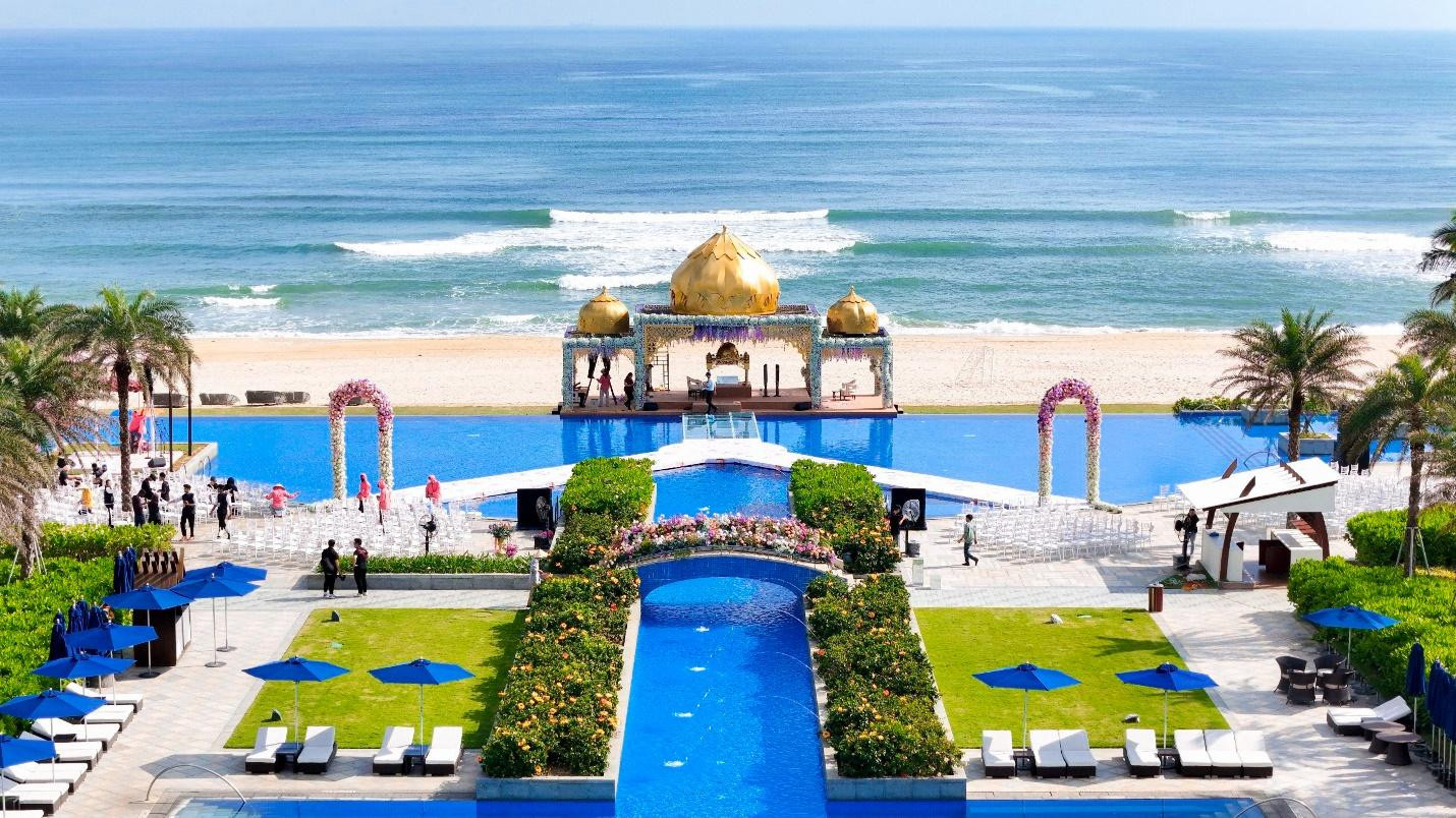 Sân khấu nơi tổ chức hôn lễ được đặt phía trên hồ bơi vô cực của khu nghỉ dưỡng với tầm nhìn hướng biển.