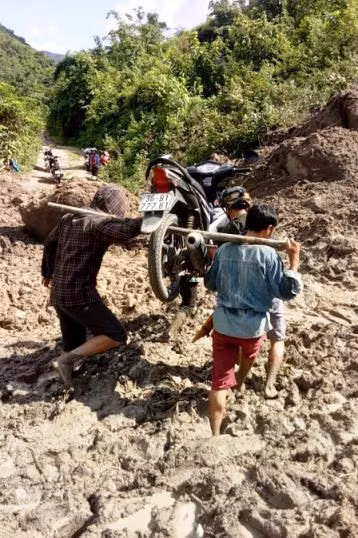 Thầy Long phải cho xe lên đòn gánh để vượt những đoạn đường bùn đất (Ảnh: Lang Văn Long)