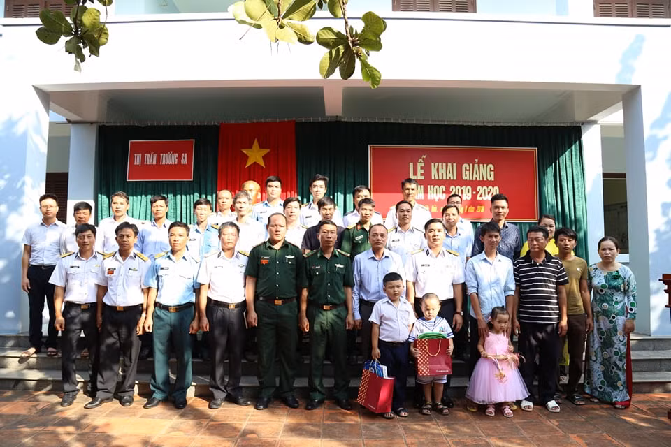 Phụ huynh, học sinh cùng các lực lượng chức năng và giáo viên cùng chụp ảnh lưu niệm nhân Lễ khai giảng. (Ảnh: H.T)