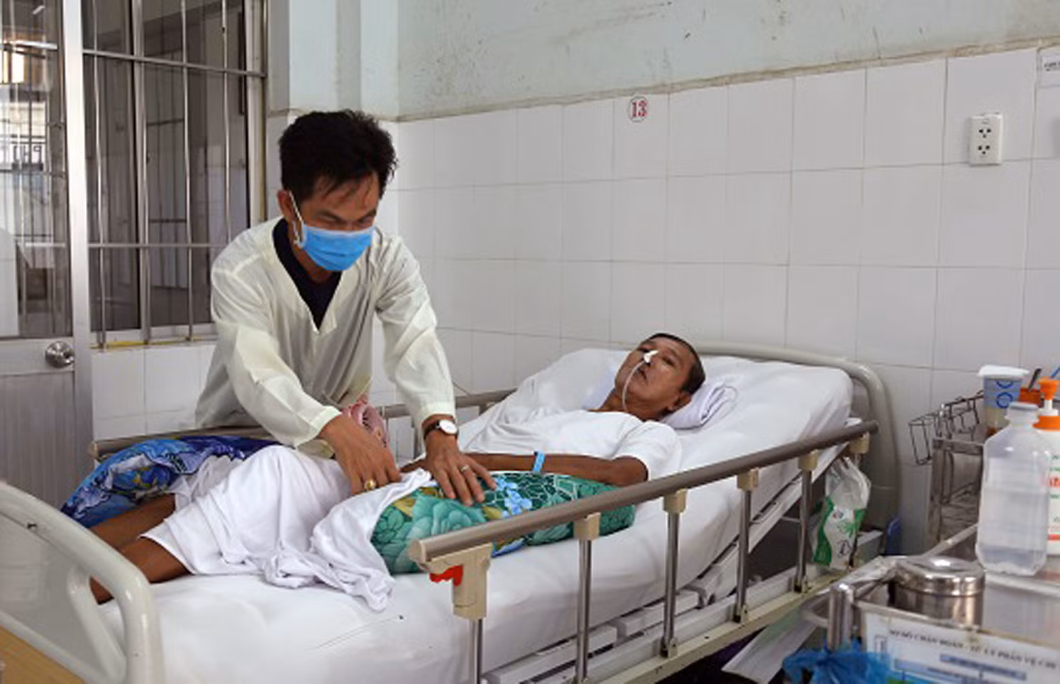 Anh Lê Tuấn Kiệt đang chăm sóc bố vợ tại bệnh viện đa khoa tỉnh Cà Mau.